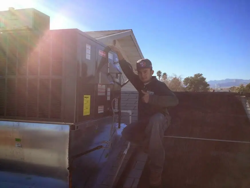 HVAC technician performing HVAC Inspection on a rooftop unit in Burlington